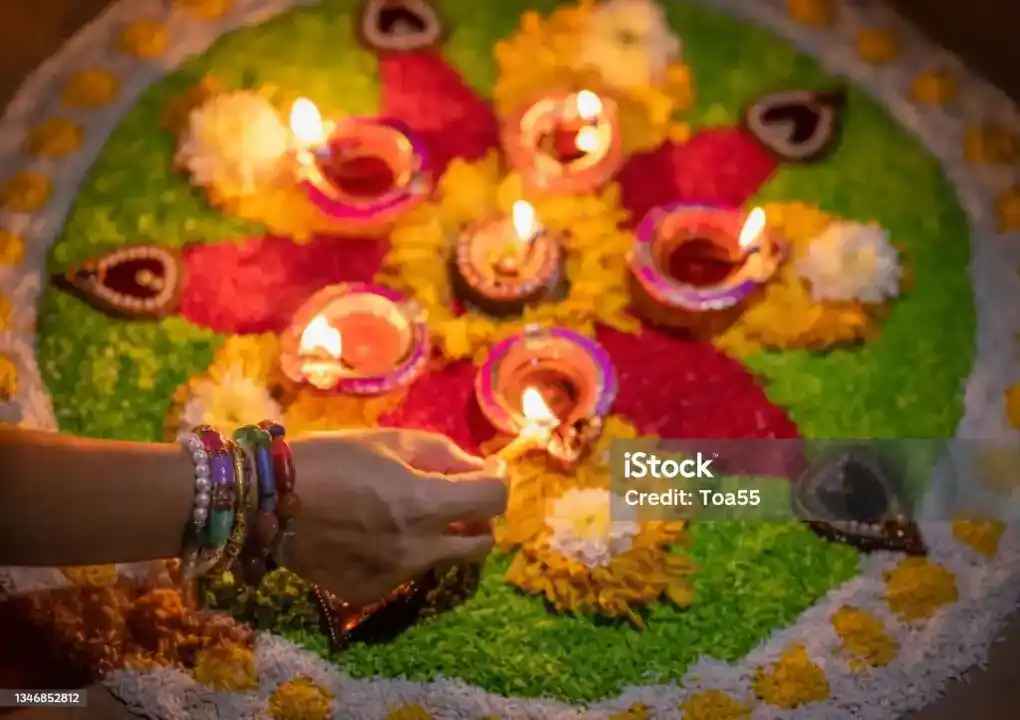 Rangoli with Flower petals, grain and lamp